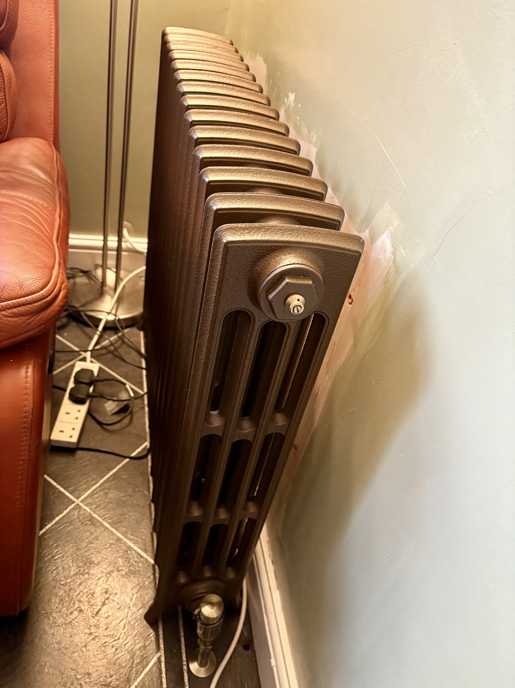 Bronze-coloured column radiator installed in a living room